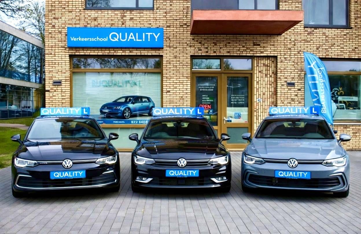 Drie Volkswagen Golf-lesauto's van Rijschool Quality met blauwe daklichtborden voor het pand aan de Vondelstraat in Alkmaar